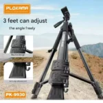 PLOKAMA PK-9930 150cm professional tripod stand fully extended with a camera and mobile phone mount attached in a photography studio setting.